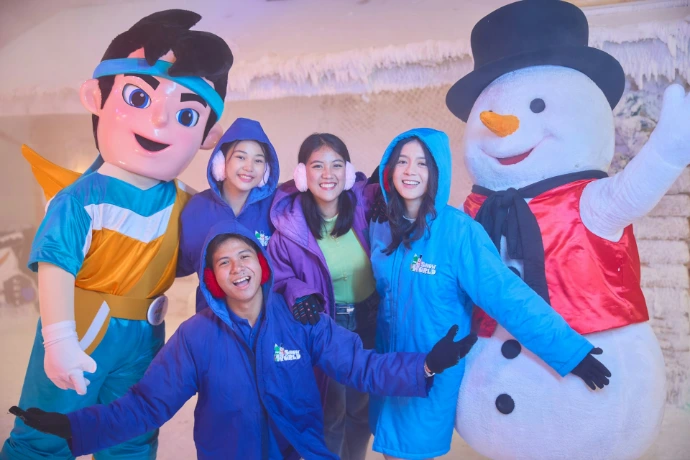 People in winter gear with mascots and snowman
